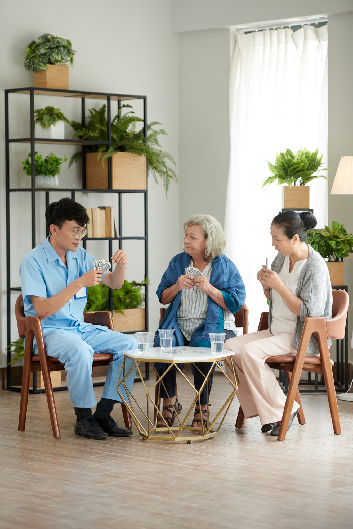 Senior People Playing Cards with Caregiver